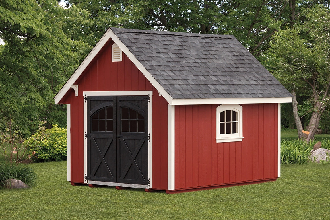 Red storage shed with black doors and white trim in a garden setting