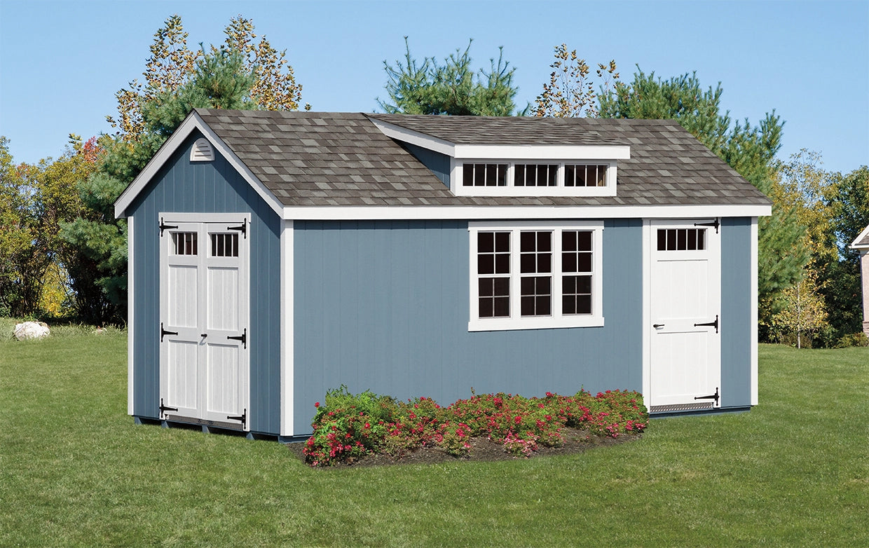 Blue storage shed with white doors and windows on a grassy area with trees in the background.
