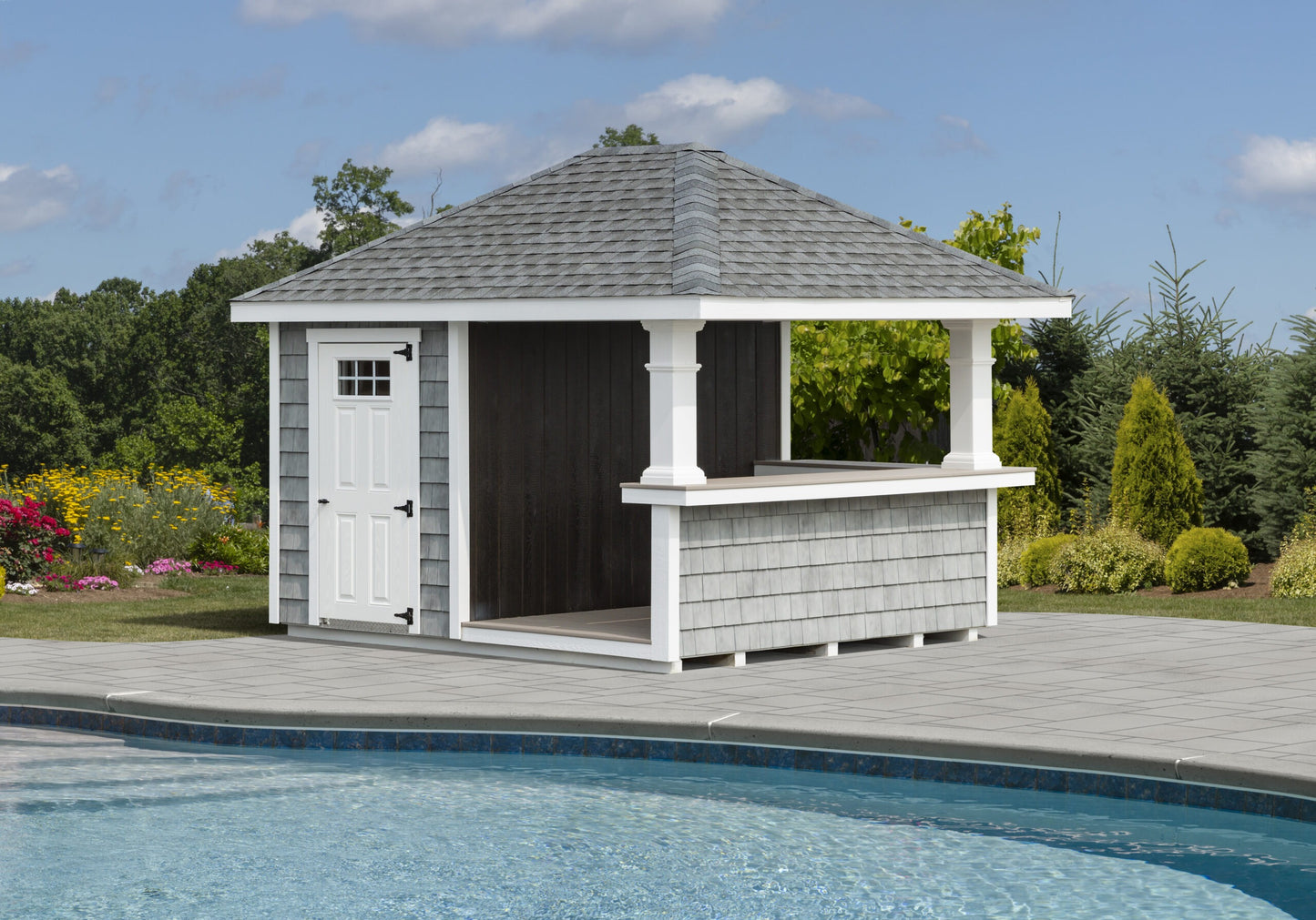 Gazebo with a bar attached next to a pool on a sunny day.