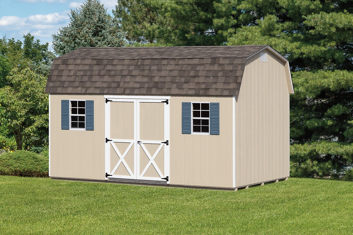 Beige storage shed with a brown roof on a grassy area with trees in the background