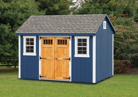 Blue storage shed with wooden doors on a grassy area with trees in the background