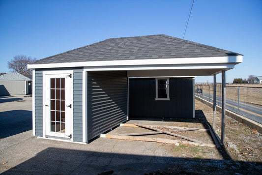 Small building with a gray roof and white walls on a clear day.