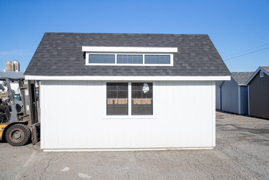 Small white building with a gray roof in an outdoor setting