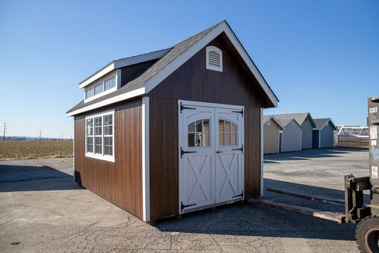 Small wooden building with a white door in an outdoor setting