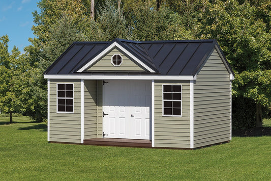 Small storage shed with a black roof in a grassy area with trees